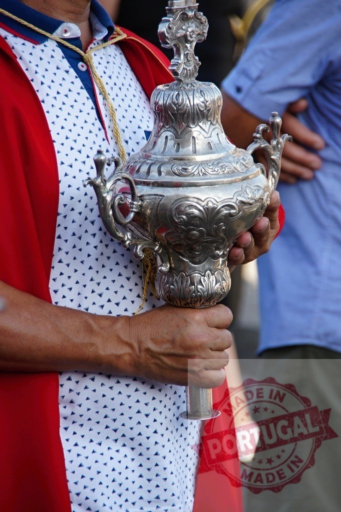 Man holding ornate silver religious vessel in procession | Man holding an ornate silver vessel during a traditional religious ceremony - Realisiert mit Pictrs.com