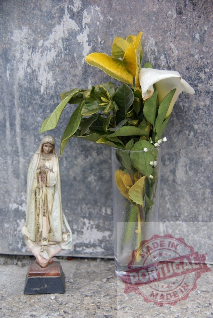 Virgin Mary statue with flowers at a memorial shrine | Virgin Mary statue and calla lily flowers in a vase standing at a religious memorial shrine - Realisiert mit Pictrs.com