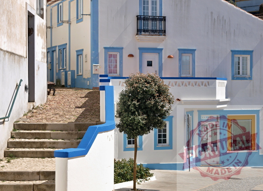 Portuguese town street with traditional white and blue buildings | Town street with traditional Portuguese buildings painted white and blue under clear sky - Realized with Pictrs.com