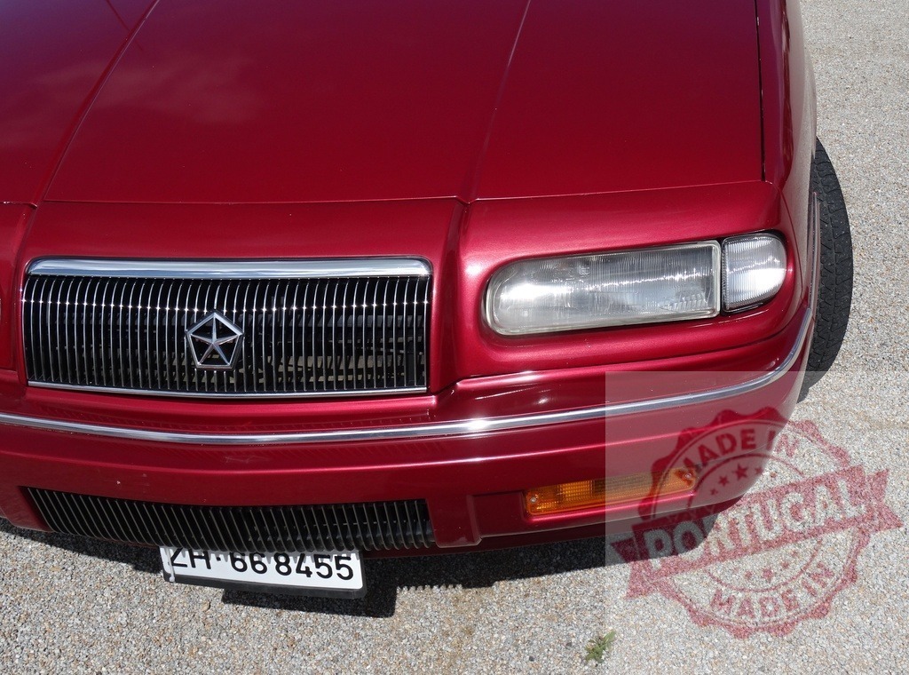 Red Chrysler sedan front grille and headlight | Red Chrysler car showing front details parked on a sunny day - Realisiert mit Pictrs.com