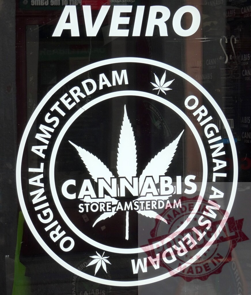 Cannabis store sign from Amsterdam concept in Aveiro | Cannabis store logo with leaf and Amsterdam text displayed on Aveiro shop window - Realized with Pictrs.com
