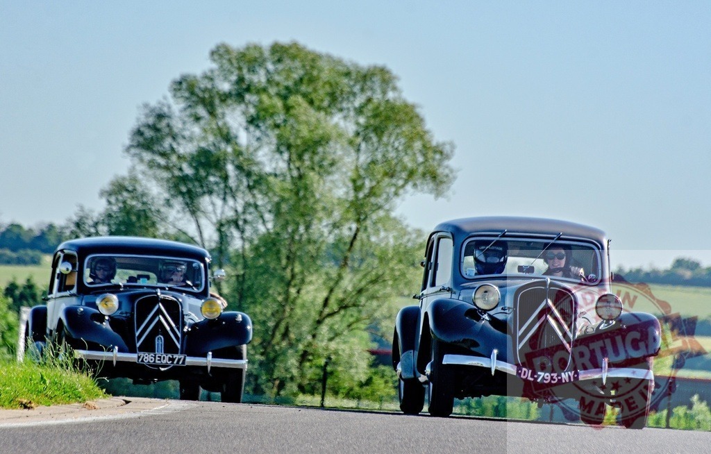 Two vintage Citroën Traction Avant cars participating in a rally | Classic cars driving on a rural road during a historic automobile event - Realized with Pictrs.com