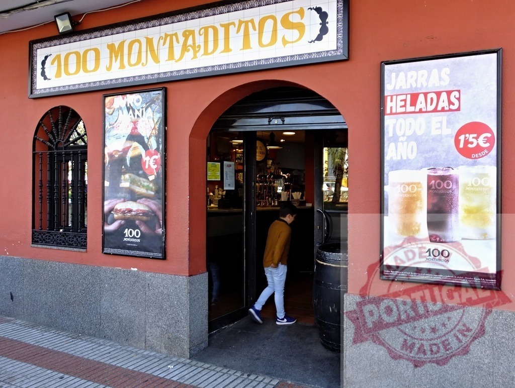 100 Montaditos restaurant entrance in Madrid Spain | 100 Montaditos restaurant facade with a boy walking into the entrance - Realisiert mit Pictrs.com