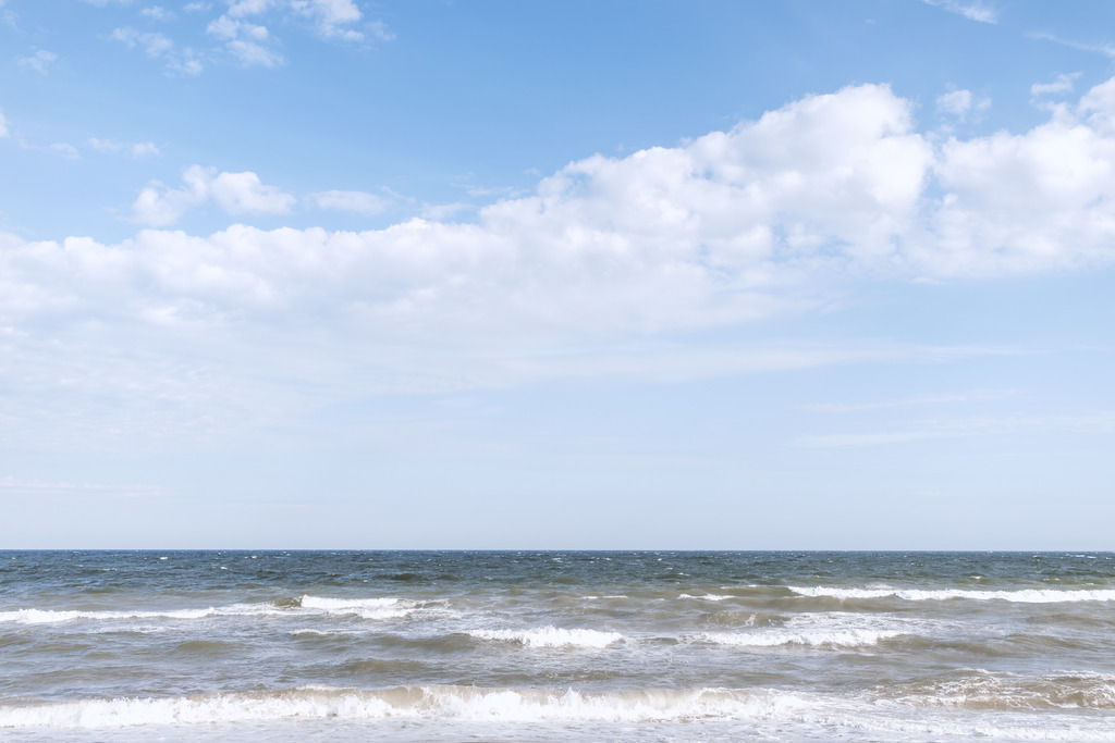 Wandbild: Wellenweite vor Schönhagen | Vor Schönhagen treffen bewegte Wellen auf die Ostsee, weißer Schaum bricht über dem Wasser, und der Horizont öffnet sich unter einem hellen Himmel mit leichten Wolken. Die Mischung aus Dynamik im Meer und Ruhe im Himmel verleiht dem Motiv eine besondere Küstenatmosphäre. Dieses Wandbild bringt die natürliche Weite und die lebendige Frische der Schönhagener Ostseeküste direkt in den Raum.