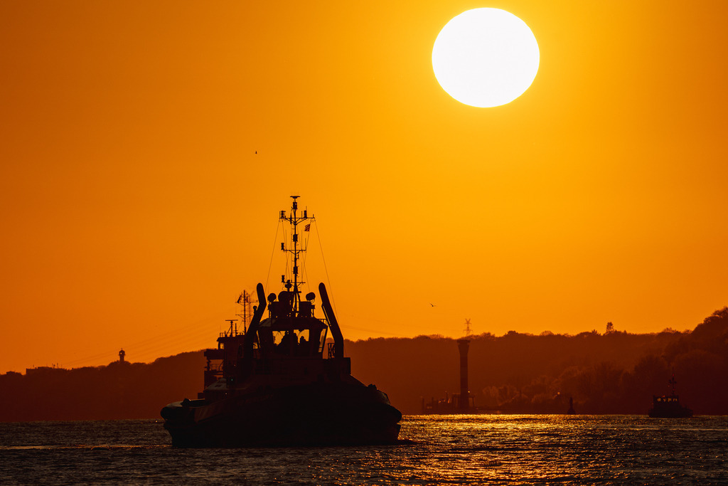 Schlepper-Silhouette im Sonnenuntergang mit voller Sonne | Schlepper-Silhouette im Sonnenuntergang mit voller Sonne - Realisiert mit Pictrs.com