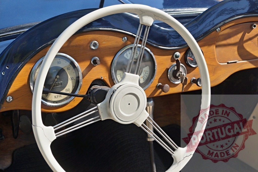 Vintage car interior with wooden dashboard and white steering wheel | Close up view of classic automobile dashboard featuring a white steering wheel and gauges - Realized with Pictrs.com