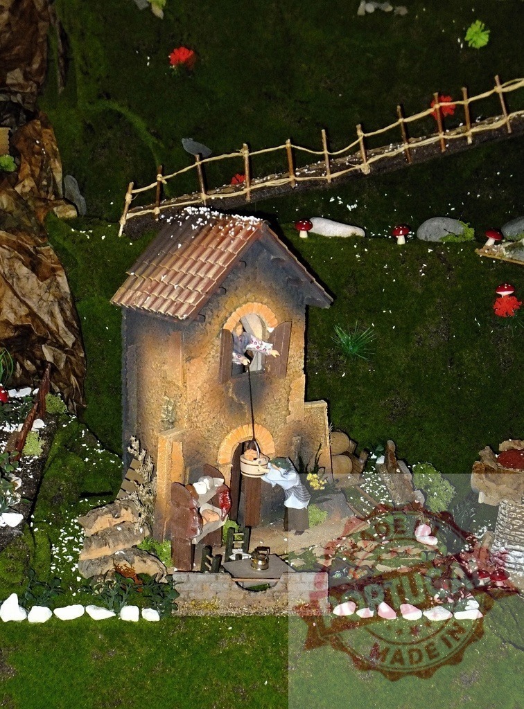 Medieval house with well and people taking water in miniature christmas village | Miniature medieval house with well and people taking water in a christmas village, representing everyday life in middle ages - Realisiert mit Pictrs.com
