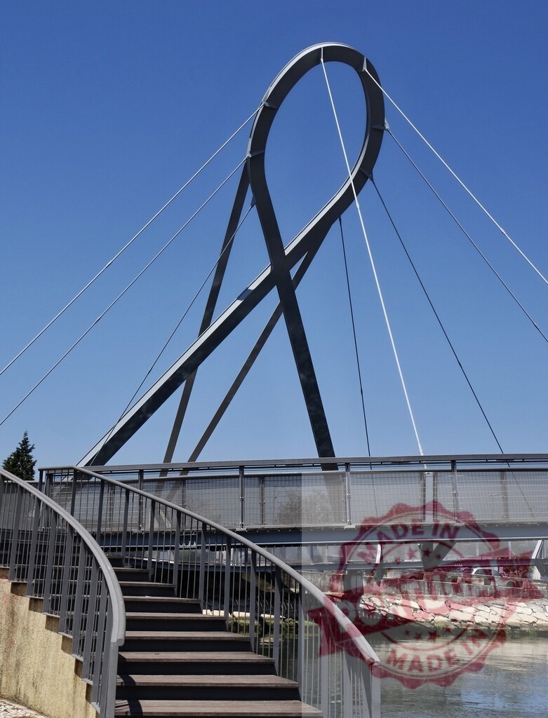 Pérola de Aveiro Bridge ribbon architecture spanning canal | Pérola de Aveiro pedestrian bridge featuring unique ribbon-like steel structure and suspension cables - Realized with Pictrs.com