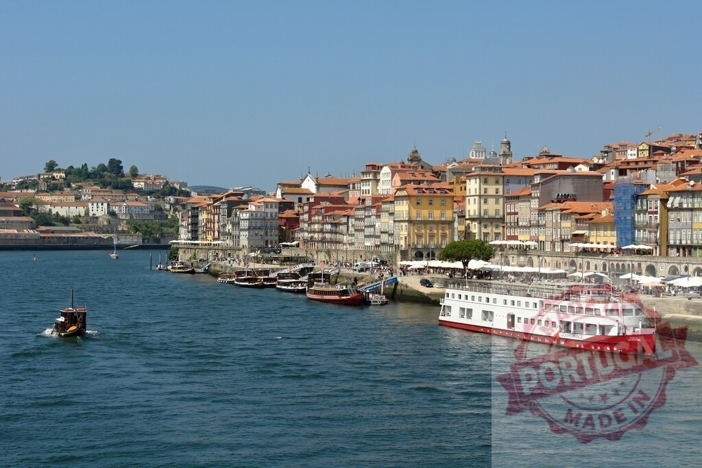 Porto cityscape along Douro river with Ribeira buildings. Porto - Portugal | Douro river flowing past colorful historic buildings in the Ribeira district of Porto, Portugal - Realized with Pictrs.com