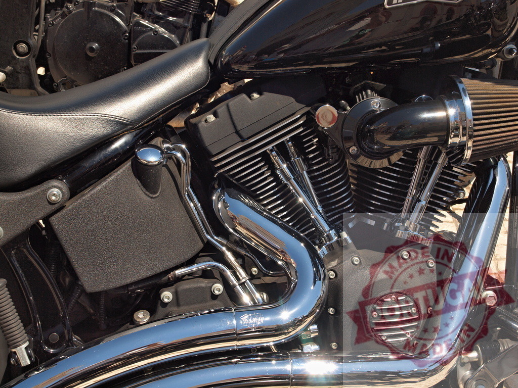 Harley-Davidson motorcycle engine with shining chrome exhaust | Close-up of a powerful motorcycle V-twin engine with chrome exhaust pipes and black details - Realized with Pictrs.com