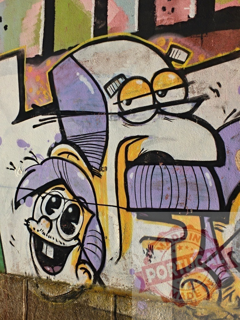 Funny cartoon characters showing graffiti art on a concrete wall | Two funny cartoon characters painted with spray paint on a concrete wall as graffiti art - Realisiert mit Pictrs.com
