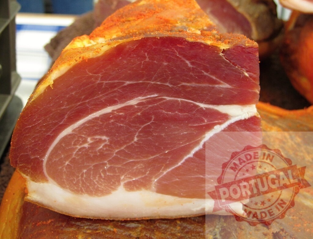 Smoked ham close up with paprika seasoning | Cured ham with thick fat layer and red pepper seasoning, displaying marbling texture - Realized with Pictrs.com