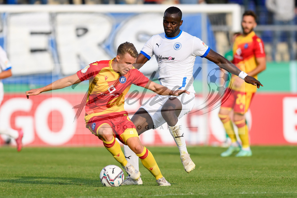 LOTKSC20210809_022 | Fussball, Herren: Christoph Kobald (Karlsruher SC) und Exauce Andzouana (Sportfreunde Lotte) im Zweikampf beim Spiel der 1. Runde im DFB-Pokal zwischen SF Lotte und Karlsruher SC im Stadion am Lotter Kreuz am 09.08.2021 in Lotte, Deutschland.DFB / DFL REGULATIONS PROHIBIT ANY USE OF PHOTOGRAPHS AS IMAGE SEQUENCES AND/OR QUASI-VIDEO. - Realisiert mit Pictrs.com