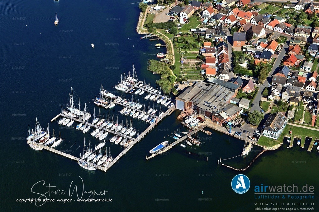 Luftbild Yachthafen Massholm - Zuvor war der Handel und die Frachtensegelei die Haupterwerbsquelle | Zuvor war der Handel und die Frachtensegelei die Haupterwerbsquelle. 1835 verfügte Maasholm bereits über eine Flotte von 29 Schiffen, und der Bau der künstlichen Schleimündung durch den Olpenitzer Landarm führte zu einem erheblichen Aufschwung. Der große Schiffsverkehr erforderte sogar einen königlichen Zollkontrolleur. Die Gemeinde wurde mehrfach im Wettbewerb „Unser Dorf hat Zukunft“ ausgezeichnet.