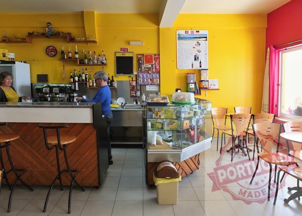 Woman and man working in a small local cafe | People working and a vibrant interior of a local cafe with yellow walls and wooden furniture - Realisiert mit Pictrs.com