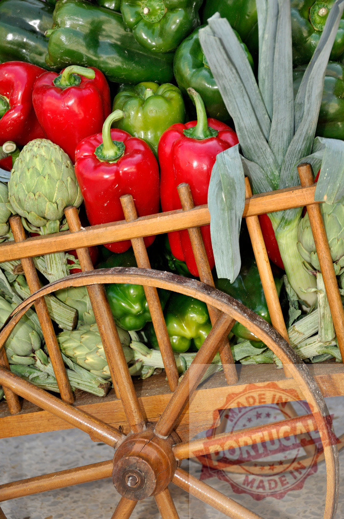 Fresh vegetables in wooden cart at market display | Colorful bell peppers, artichokes, and leeks are filling a rustic wood cart - Realized with Pictrs.com