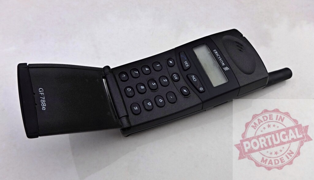 Ericsson GF788e mobile phone showing keypad and small screen | Old Ericsson GF788e mobile phone with flip cover open, showing keypad and small screen, lying on white surface - Realisiert mit Pictrs.com