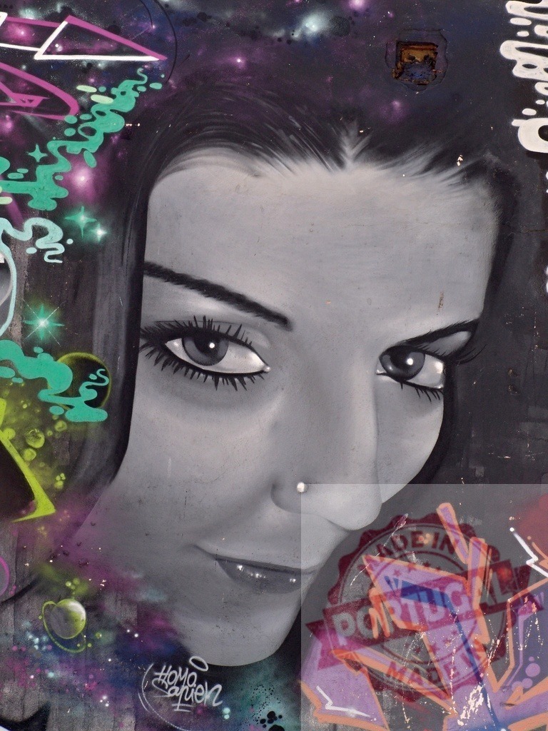Mysterious woman with nose piercing posing in colorful space graffiti | Urban art portrait of enigmatic female with captivating gaze and nose piercing against vibrant cosmic backdrop - Realized with Pictrs.com