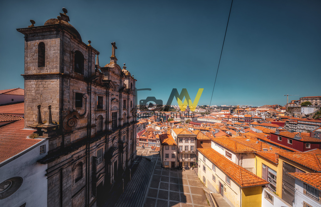 Panorama Weitwinkel Aufnahme über die Stadt Porto,blauer Himmel  | Das Bild zeigt eine Szene aus der historischen Altstadt von Porto, Portugal. Die Szene zeigt eine steile, gepflasterte Straße oder Treppe, die hinunter in Richtung des Douro-Flusses führt.An der linken Seite sind Verkaufsstände mit lokalen Textilien und Souvenirs aufgebaut.Bunte Fähnchen sind über die Gasse gespannt und sorgen für eine festliche Atmosphäre. - Realisiert mit Pictrs.com