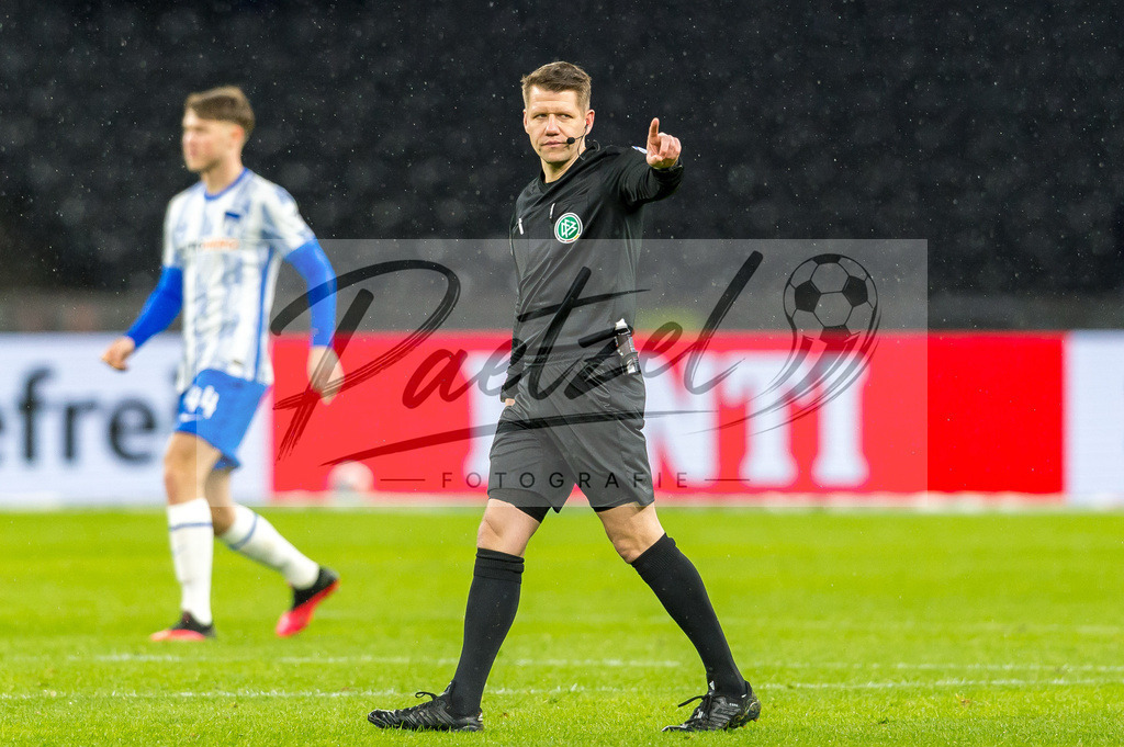 BSCRBL20220220_159 | Fussball, Herren: Schiedsrichter Patrick Ittrich gestikuliert, Gestik bei dem Spiel der 1. Bundesliga zwischen Hertha BSC und RB Leipzig im Olypiastadion am 20.02.2022 in Berlin, Deutschland.DFB / DFL REGULATIONS PROHIBIT ANY USE OF PHOTOGRAPHS AS IMAGE SEQUENCES AND/OR QUASI-VIDEO. - Realisiert mit Pictrs.com
