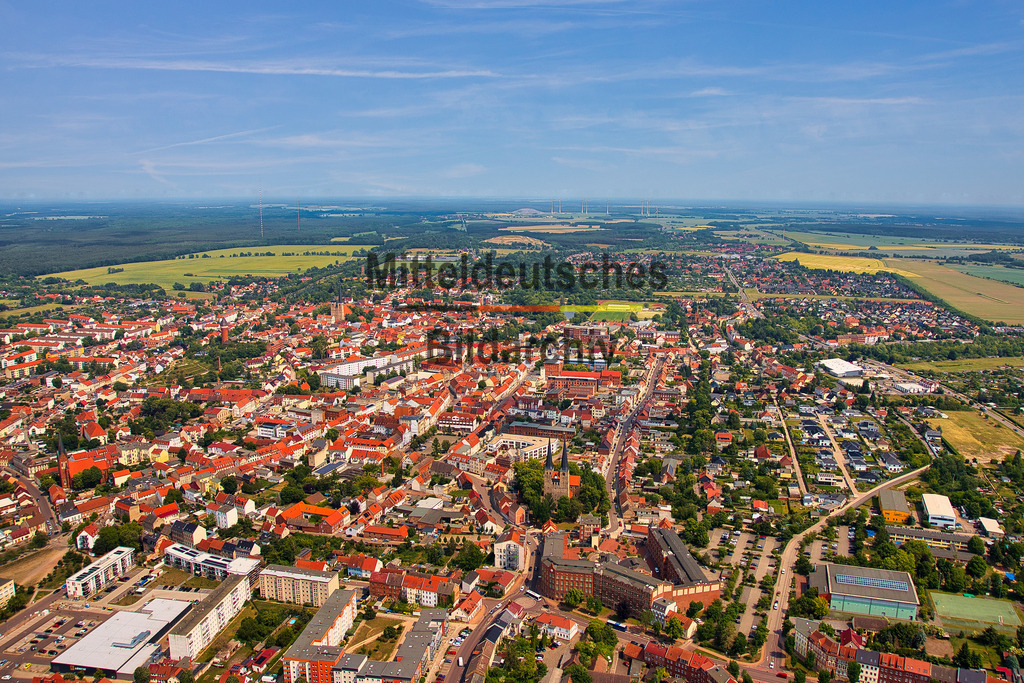 Burg-Jerichower-Land-Luftbild- Sachsen-Anhalt_4133 | Die Luftaufnahme zeigt Burg mit seiner historischen Innenstadt, den markanten Kirchen und erhaltenen Teilen der früheren Stadtbefestigung. Besonders die Kirchtürme und der Wehrturm setzen weithin sichtbare Akzente im Stadtbild. Aus der Vogelperspektive wird die gewachsene Struktur der Kreisstadt im Jerichower Land deutlich. - Realisiert mit Pictrs.com