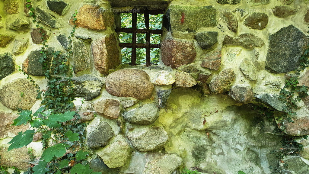 Felswandmauer des Wasserturmes aus Lietzow | Die Felswandmauer des alten Wasserturms aus Lietzow hat eine besondere mittelalterliche Wandstruktur  aus Feldsteinen mit einem gusseisernen Fenstergitters - Realisiert mit Pictrs.com