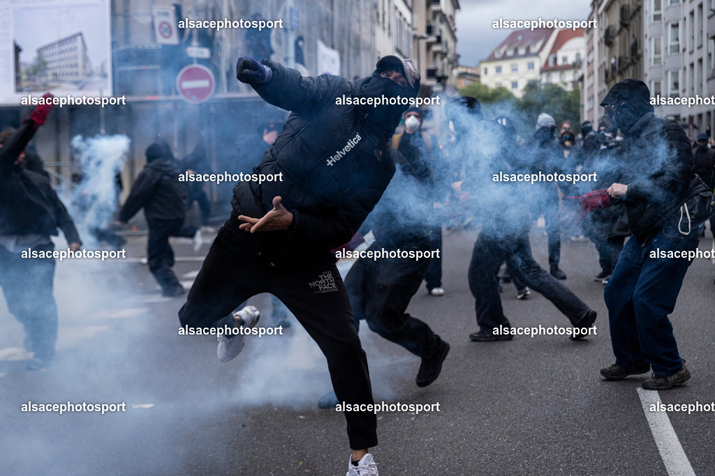 9L6A6252 | Strasbourg, France, 24 octobre 2026. Des manifestants affrontent les forces de l’ordre lors d’une mobilisation dans le centre-ville de Strasbourg. Des policiers interviennent pour disperser des groupes de manifestants, tandis que des gaz lacrymogènes sont utilisés. Des affrontements, des jets de projectiles et des dégradations sont observés dans plusieurs rues. Des barricades et des véhicules en feu témoignent de la tension qui règne en marge de la mobilisation. - Realisiert mit Pictrs.com