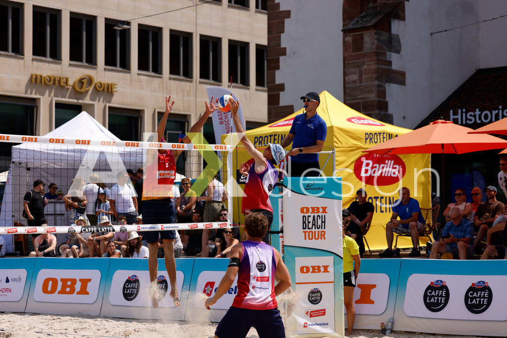 Obi BeachTour 2026 - Basel | BASEL, SWITZERLAND - JULY 19: SIMON HAGENBUCH (SUI) attack / spike against LUC EMANUEL FLÜCKIGER (SUI) block during the Obi BeachTour 2026 match between DILLIER / FLÜCKIGER (SUI) and HAGENBUCH / HAUSSENER (SUI) at Barfüsserplatz on July 19, 2026 in Basel, Switzerland. - Realisiert mit Pictrs.com