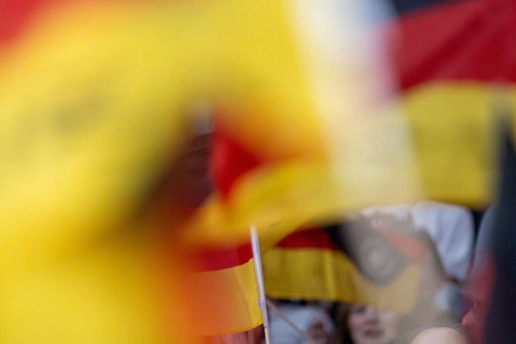 Fans mit Deutschland-Fahnen als Symbolbild für Public Viewing | Nahaufnahme von Fahnen schwenkenden deutschen Fans - Realisiert mit Pictrs.com