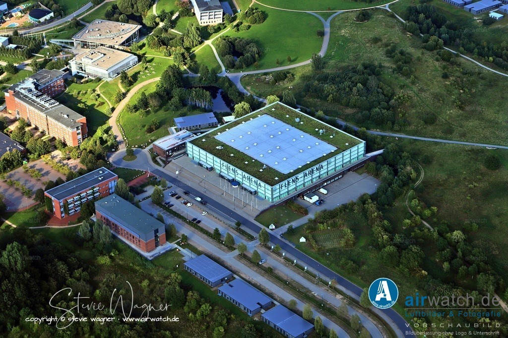 Luftbild Flensburg, Sandberg, Europa Universitaet Flensburg, Flens Arena, Campusallee 2, 24943 Flensburg | Flens-Arena, offiziell GP JOULE Arena, ist eine Mehrzweckhalle im Stadtteil Sandberg der schleswig-holsteinischen Stadt Flensburg, die auf dem Hochschulcampus der Universität Flensburg und der Hochschule Flensburg liegt. Sie wurde 2001 eröffnet und dient seitdem als Heimspielstätte der SG Flensburg-Handewitt, die dort seit dem 2. Dezember 2001 ihre Heimspiele austrägt. Die Halle verfügt über eine Kapazität von 6.300 Plätzen und ist bekannt für ihre große Stehplatztribüne, die die größte der LIQUI MOLY Handball-Bundesliga ist und bis zu 1.500 Zuschauer aufnehmen kann.