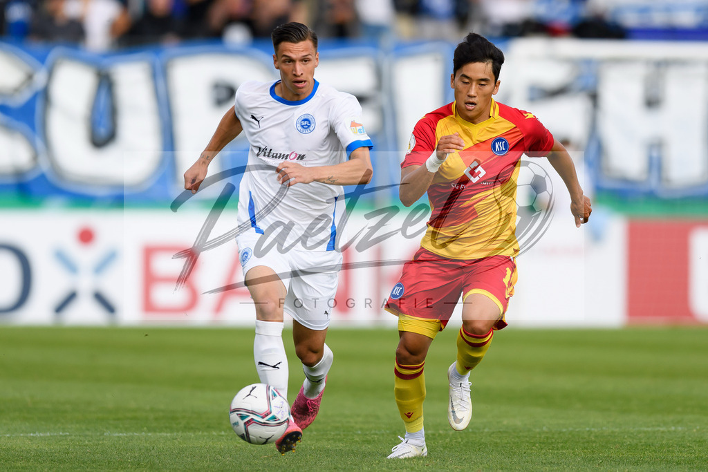 LOTKSC20210809_076 | Fussball, Herren: Tyson Richter (Sportfreunde Lotte) und Kyoung-rok Choi (Karlsruher SC) im Zweikampf beim Spiel der 1. Runde im DFB-Pokal zwischen SF Lotte und Karlsruher SC im Stadion am Lotter Kreuz am 09.08.2021 in Lotte, Deutschland.DFB / DFL REGULATIONS PROHIBIT ANY USE OF PHOTOGRAPHS AS IMAGE SEQUENCES AND/OR QUASI-VIDEO. - Realisiert mit Pictrs.com