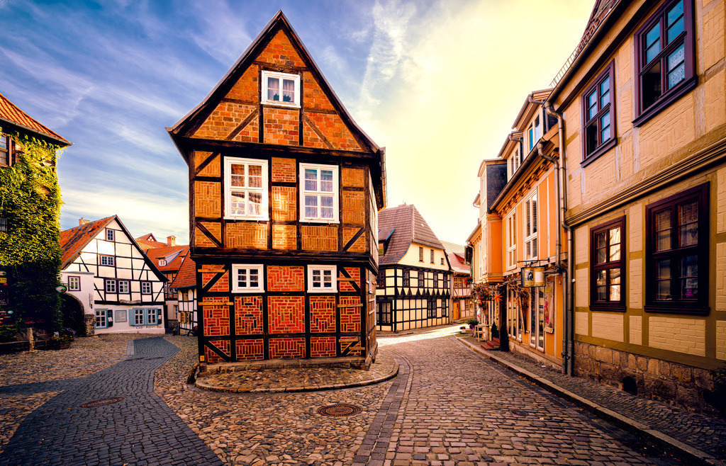 Malerische bekannte Szene mit Fachwerkhäusern aus Quedlinburg | Das Bild zeigt den Finkenherd in der Welterbestadt Quedlinburg. Ort: Der Finkenherd ist ein bekannter, historischer Platz in der Altstadt von Quedlinburg am Fuße des Schlossberges. Architektur: Die Szene ist geprägt von zahlreichen gut erhaltenen Fachwerkhäusern, die typisch für die Stadt sind. Bedeutung: Quedlinburg ist UNESCO-Weltkulturerbe und gilt mit über 2000 Fachwerkhäusern als eines der größten Flächendenkmale in Deutschland.  - Realisiert mit Pictrs.com