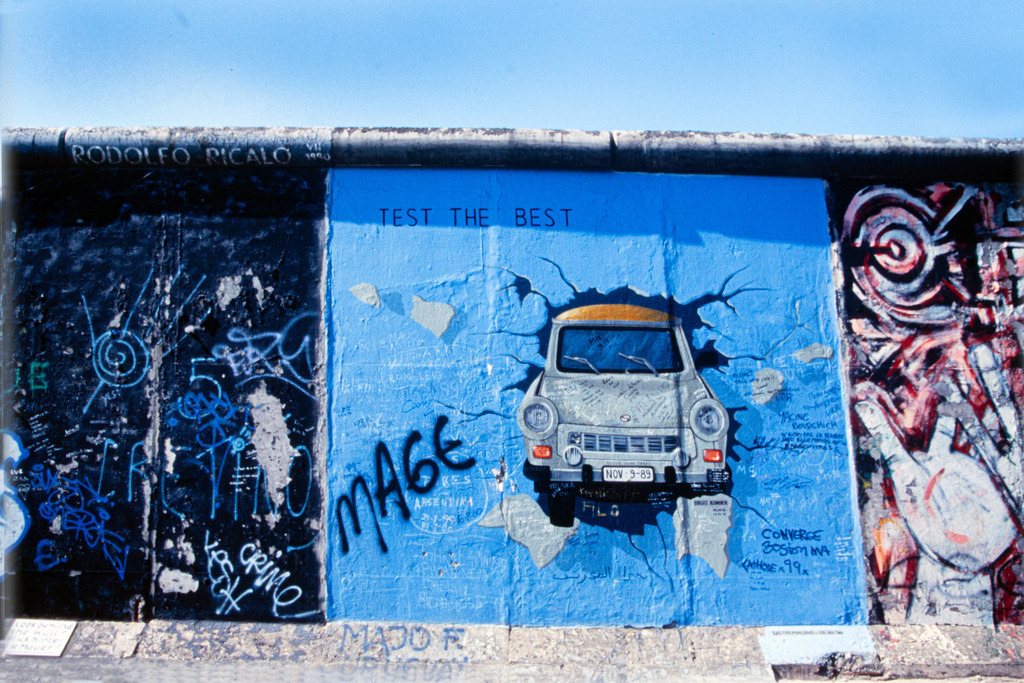 Berlin_Mauer_4-2000_10147a | Streetart, Trabi durchbricht blaue  Wand.