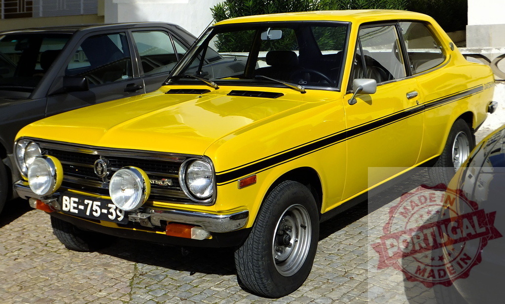 Yellow Datsun 1200 Sunny Excellent parked on cobblestone street | Classic yellow Datsun 1200 Sunny Excellent parked on a cobblestone street, showcasing its vintage charm - Realized with Pictrs.com