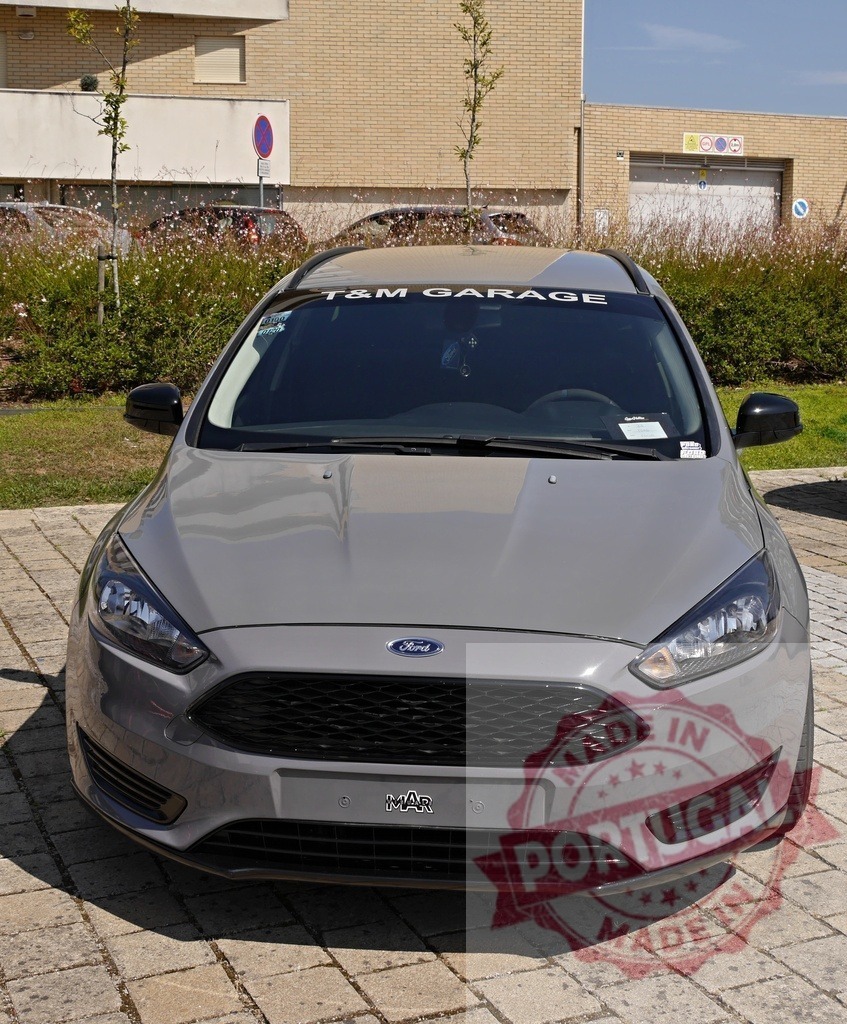 Gray Ford Focus hatchback parked at T&amp;M Garage | Gray Ford Focus hatchback showcasing tuning culture and automotive style at a garage - Realisiert mit Pictrs.com