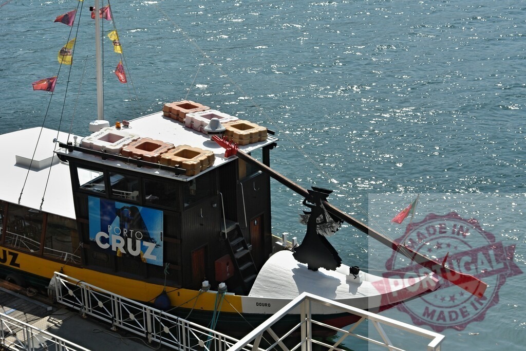 Rabelo boat on Douro river, Porto Cruz brand. Porto - Portugal | Gondola-like rabelo boat displaying Porto Cruz brand at a sunny pier in Porto - Realisiert mit Pictrs.com