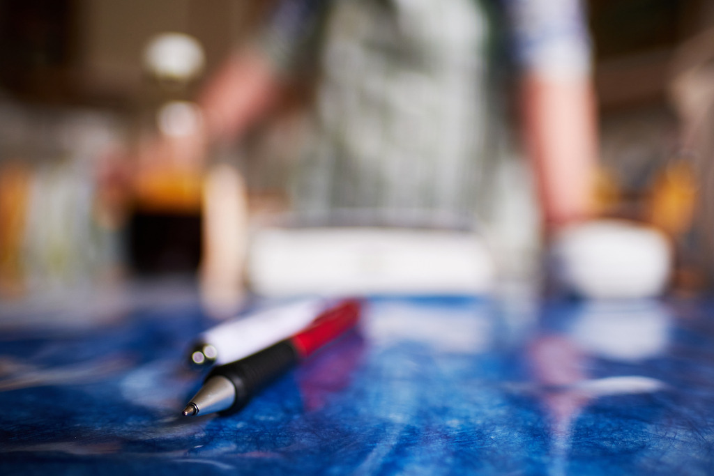 Zwei Schreibgeräte liegen auf dem Küchentisch | Austria - March 28, 2021: Zwei Schreibgeräte liegen auf dem Küchentisch, dahinter die Köchin. - Realisiert mit Pictrs.com