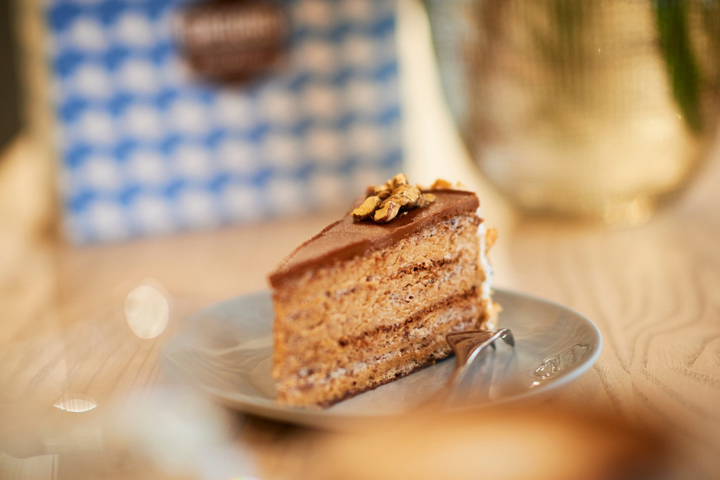 Gregors Konditorei | Wien, Austria - October 20, 2017: Gregors Konditorei, eine Japonaistorte steht auf dem Tisch, im Hintergrund eine Verpackung. - Realisiert mit Pictrs.com