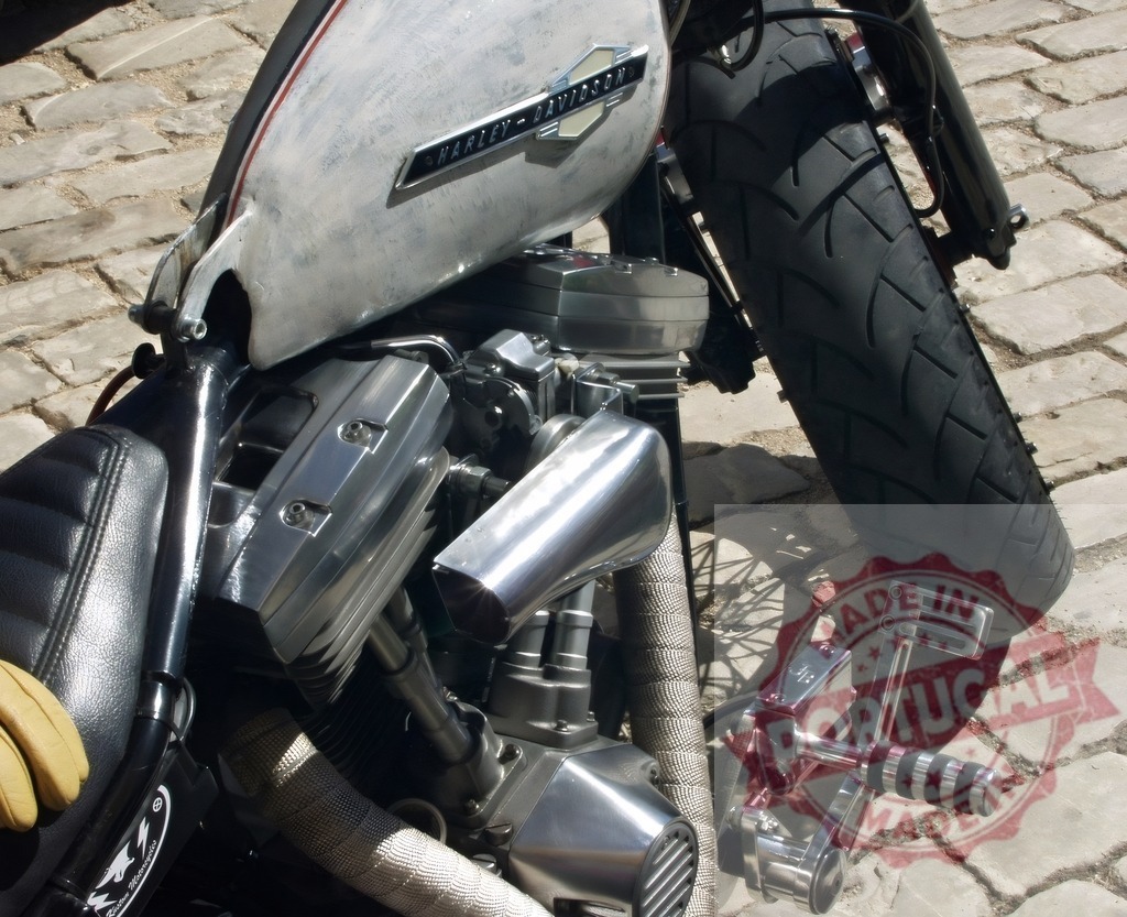 Harley-Davidson motorcycle engine on cobblestone street | Harley-Davidson motorcycle engine, gas tank, and front wheel on a cobblestone street - Realized with Pictrs.com