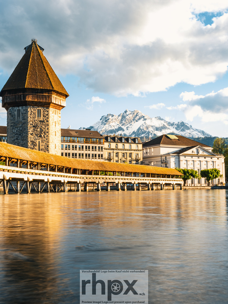 Kapellbrücke und Wasserturm Luzern im Abendlicht | Die tief stehende Sonne bricht sternförmig hinter dem Wasserturm hervor und taucht die Kapellbrücke sowie die Altstadt von Luzern in warmes Abendlicht.  - Realized with Pictrs.com