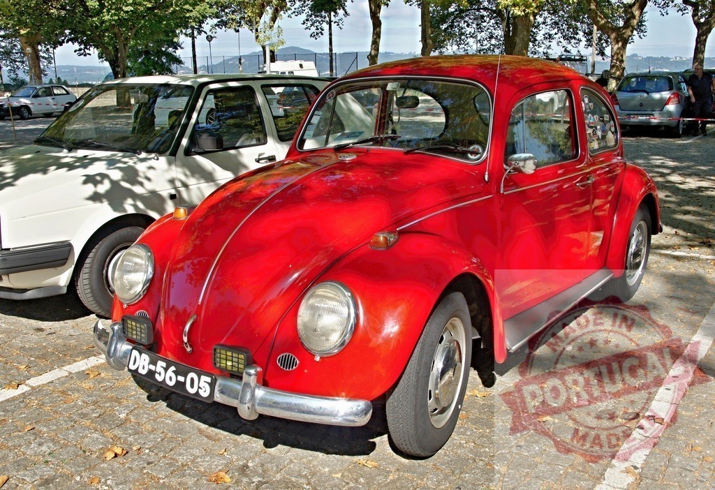 Shiny red Volkswagen Beetle parked in a parking lot | Classic red Volkswagen Beetle parked in a parking lot, representing vintage car culture and automotive history - Realisiert mit Pictrs.com