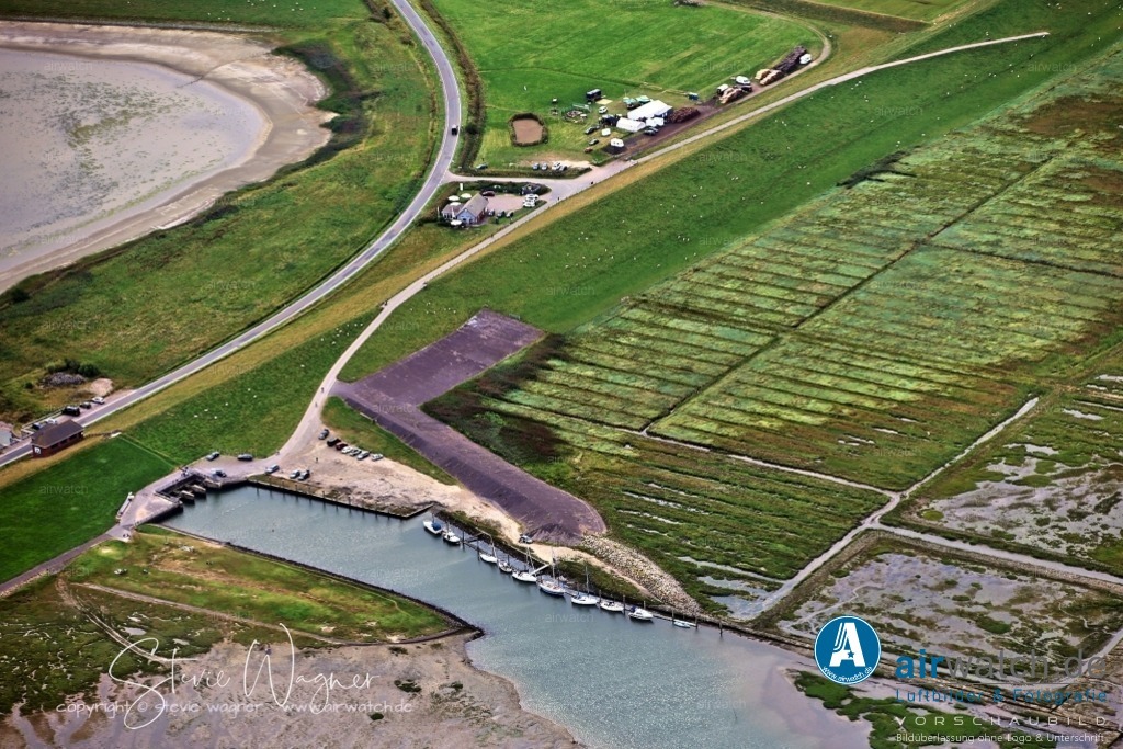 Luftbilder Everschopsiel Hafen | Sehenswürdigkeiten: 1.Lange Bank: Ein Kunstobjekt am Hafenbecken, das für Kommunikation und Attraktivitätssteigerung sorgt.2. Pier vor dem Schöpfwerk: Oft genutzt von Fischkuttern der Region.Steganlage: Für 6-10 Yachten, gut zugänglich und mit weichem Schlickgrund.3. Café Restaurant Spieskommer: Ein beliebtes Café in der Nähe des Hafens, das in der Sommerzeit geöffnet ist.