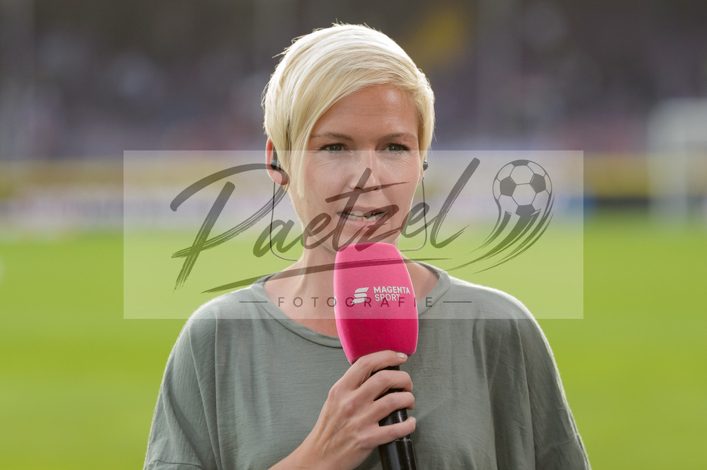 OSNVKO2021090620210906_256 | Fussball, Herren: MagetaSport-Moderatorin Anett Sattler schaut beim Spiel der 3. Liga zwischen VfL Osnabrueck und FC Viktoria Koeln im Stadion an der Bremer Bruecke am 06.09.2021 in Osnabrueck, Deutschland.DFB / DFL REGULATIONS PROHIBIT ANY USE OF PHOTOGRAPHS AS IMAGE SEQUENCES AND/OR QUASI-VIDEO. - Realisiert mit Pictrs.com