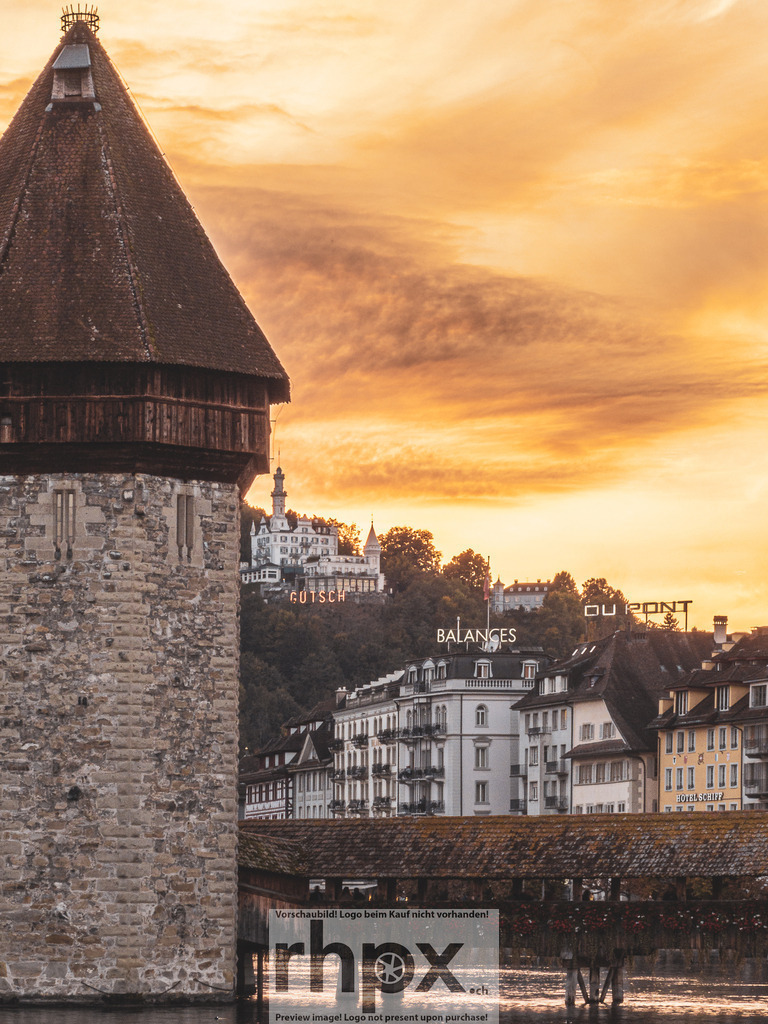Wasserturm Luzern mit Château Gütsch im Abendlicht | Stein. Gold. Geschichte.Der historische Wasserturm thront majestätisch vor einem Himmel, der in warmen Goldtönen des Abends leuchtet. Dieses sanfte Lichtspiel taucht das Luzerner Wahrzeichen und die Uferpromenade in eine Atmosphäre vollkommener Harmonie.Wähle unter "Produktauswahl" dein Wunschformat: Vom klassischen Wandbild über Puzzle &amp; Tassen bis zum digitalen Download (z.B. als Handy-Hintergrund). - Realisiert mit Pictrs.com