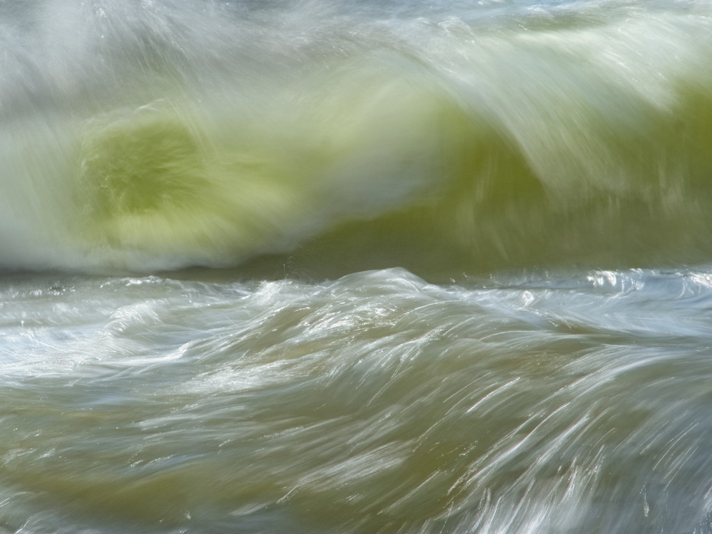 Grüne Welle | Langzeitbelichtung zweier Wellen im Uferbereich mit grünen Wasserpflanzen - Realisiert mit Pictrs.com