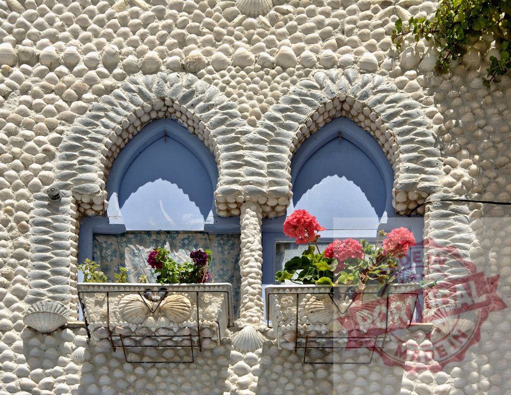 Shell House in Polperro, Cornwall featuring shell mosaic windows. Provincia de Castellon | Building facade decorated with seashells, housing two blue arched windows with flower boxes - Realized with Pictrs.com
