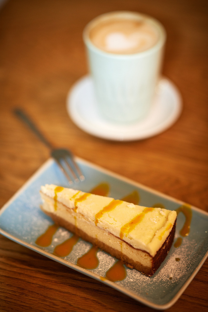 Cafe Caspar | Wien, Austria - January 14, 2019: Cafe Caspar; Cheesecake mit Mangosauce und eine Melange stehen auf dem Tisch. - Realisiert mit Pictrs.com