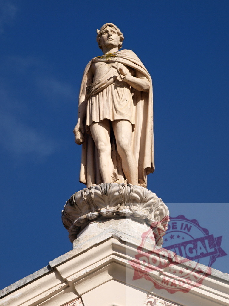 Roman male statue standing against blue sky | Classical stone statue of a man standing on a building with a clear blue sky background - Realisiert mit Pictrs.com