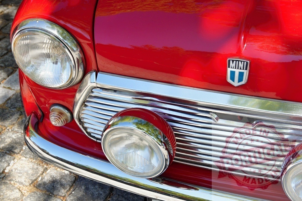 Red Mini Cooper shining parked on cobblestone street | Close-up of a classic red Mini Cooper, highlighting its iconic design and chrome details - Realisiert mit Pictrs.com