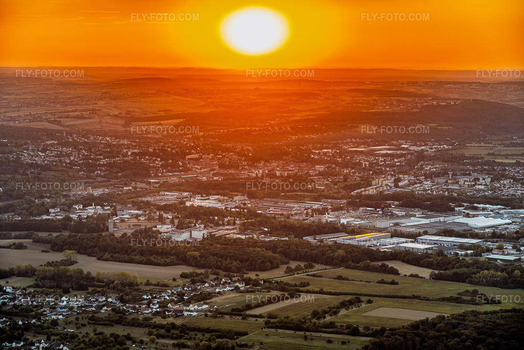 Aerial view: Sunset over Saargemünd in the district Zone Industrielle du Grand Bois in Saargemünd in the state Moselle, France. – Photo: IMG_158625.jpg taken on 08/14/2026 by Werner Riehm/FLY-FOTO.com – Resolution of the original: 6000 x 4000 px